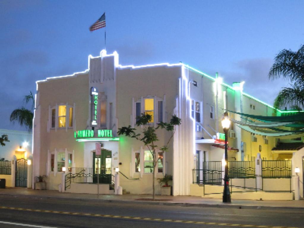 a white building with a neon sign on a street at El Primero Boutique Hotel in Chula Vista