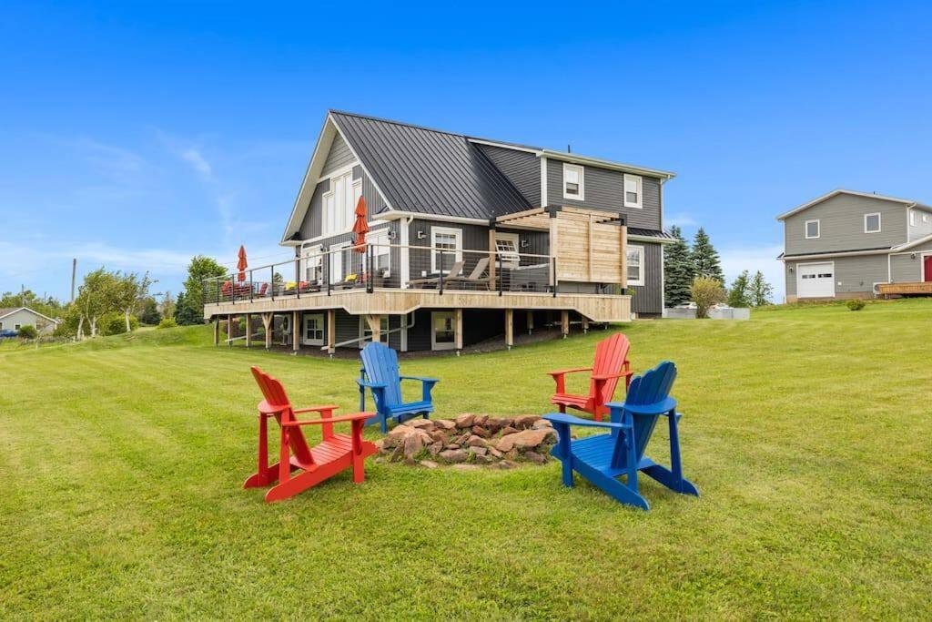 a house with four chairs sitting in the grass at Heron House in Stanley Bridge