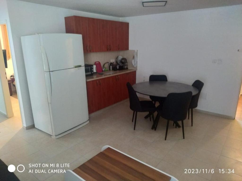 een keuken met een tafel en een witte koelkast bij amir private apartment's in Tel Aviv