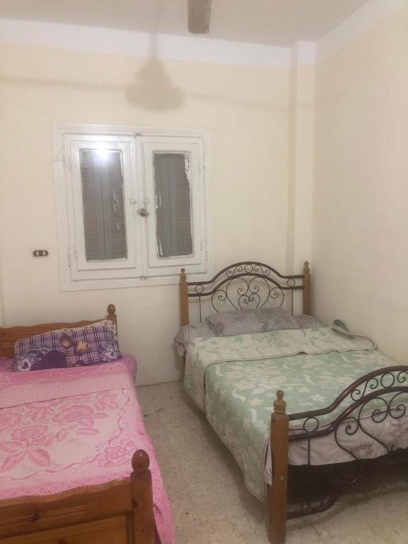 a bedroom with two beds and a window at شارع طارق مرسي مطروح in Marsa Matruh