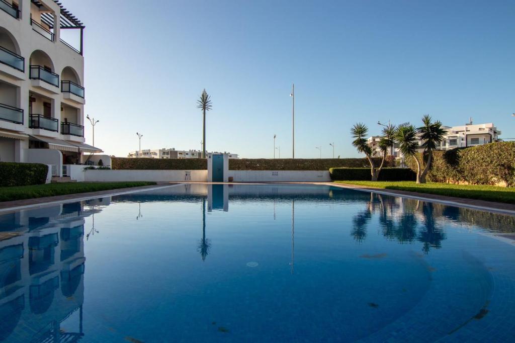 a large swimming pool in front of a building at Luxury Apartment with Pool in Agadir Bay 5 Min Walk to Beach in Agadir