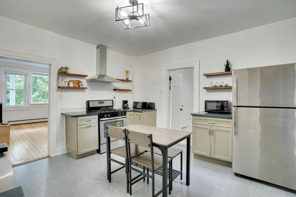 a kitchen with a table and a refrigerator at Modern Hastings-On-Hudson Home Near River! in Hastings-on-Hudson