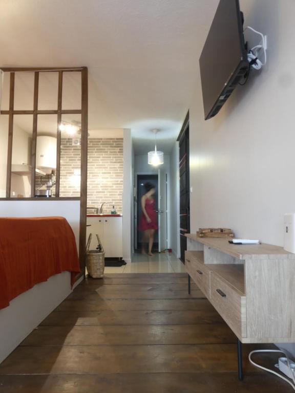 1 dormitorio con 1 cama y TV en la pared en Studio Poe Rava en Papeete