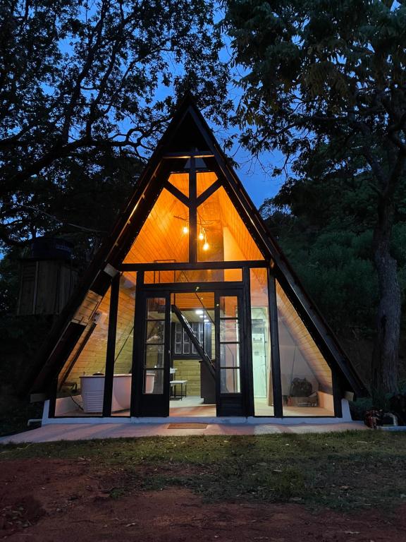 una pequeña casa con puertas de cristal en la parte delantera en Chalé Panorama en Munhoz