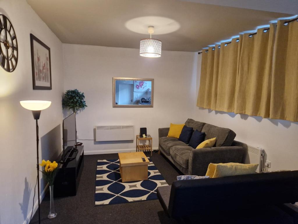 een woonkamer met een bank en een tafel bij Primos Suite - Stylish 1 Bedroom in Wallsend in Old Walker