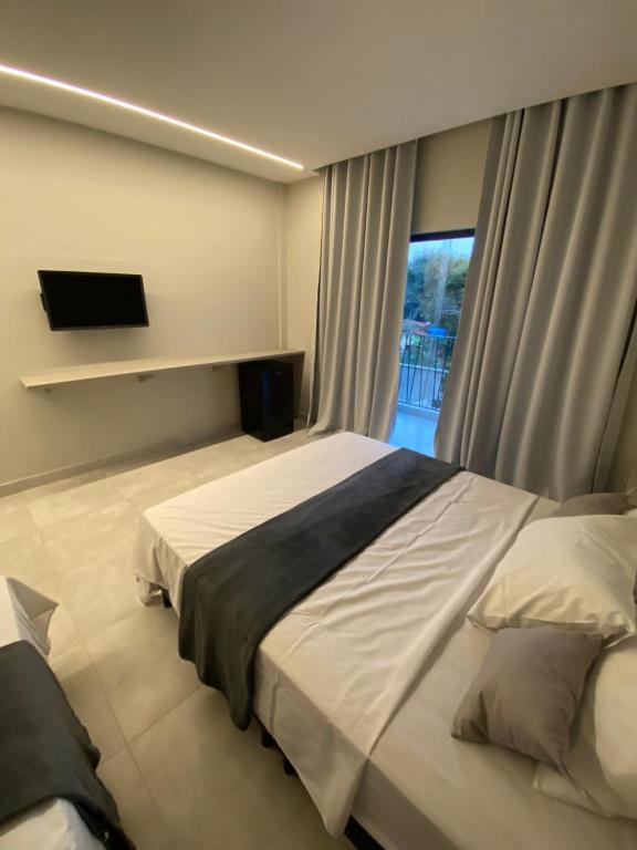 Un dormitorio con una cama grande y una ventana en Nossa suíte - Praia da Pipa, en Pipa