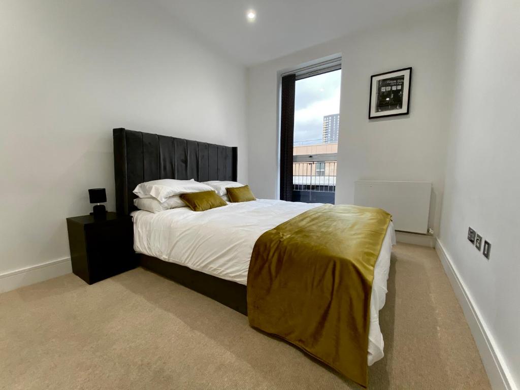 ein Schlafzimmer mit einem großen Bett und einem großen Fenster in der Unterkunft Spacious 2 Bedroom Penthouse Retreat in London