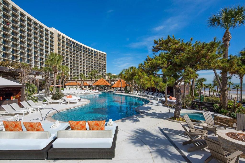 a resort swimming pool with lounge chairs and a hotel at San Luis Sunrise in Galveston