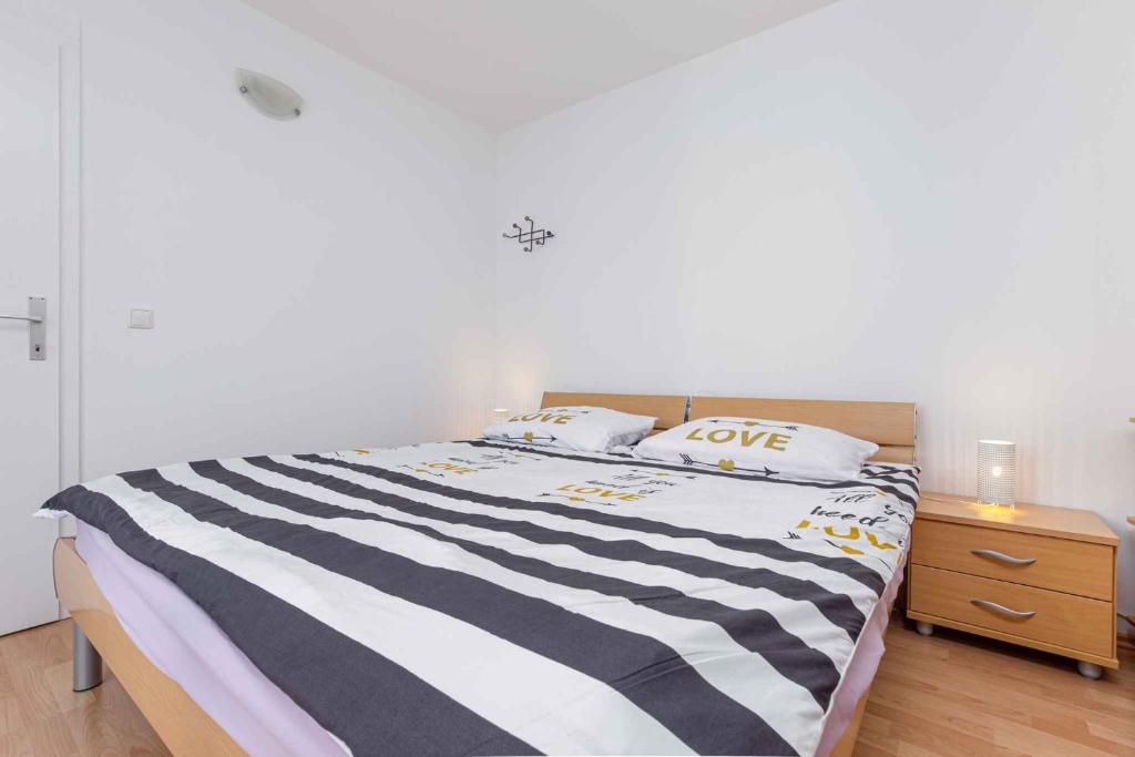 - une chambre avec un lit rayé noir et blanc dans l'établissement Apartment in Cervar Porat - Istrien 44232, à Poreč