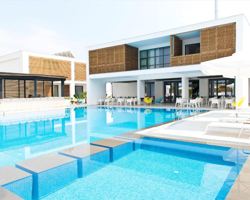 una piscina frente a un edificio en The Oak Hotel, en Keramotí