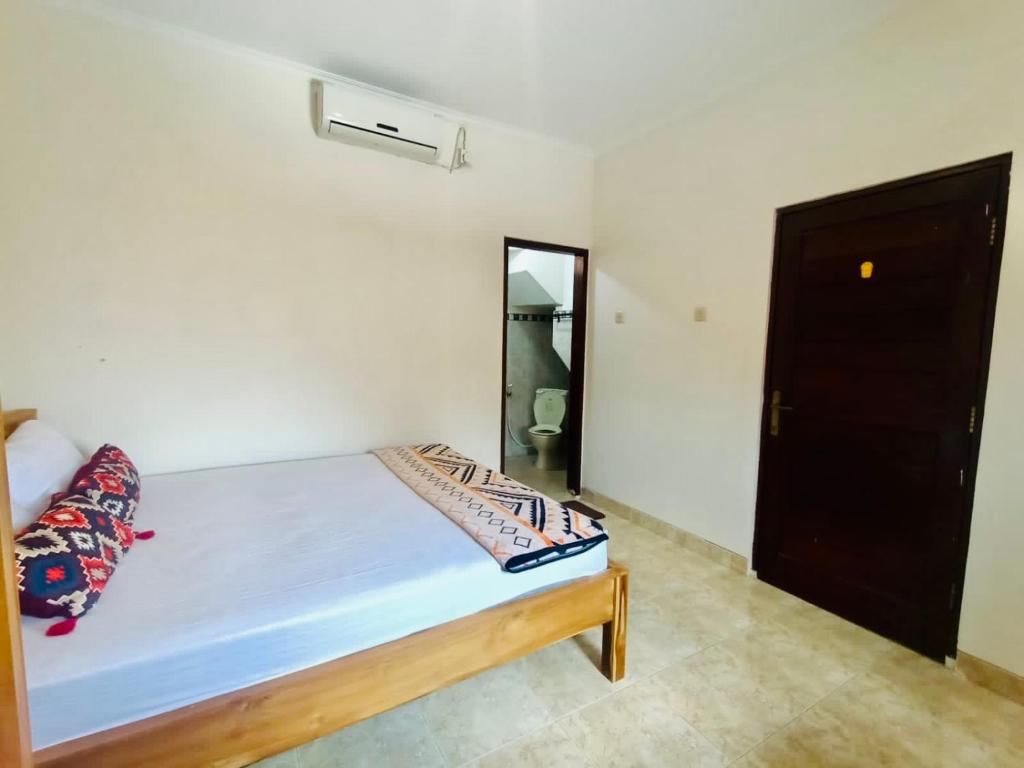 a small bedroom with a bed and a mirror at GWK View villa style house in Jimbaran