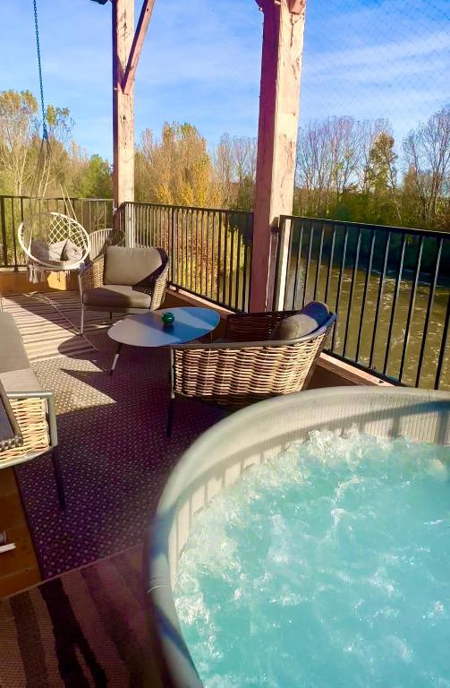 - un bain à remous sur une terrasse avec des chaises et des tables dans l'établissement Suite prestige « Paradis » 5* au Moulin d’Albias, à Albias
