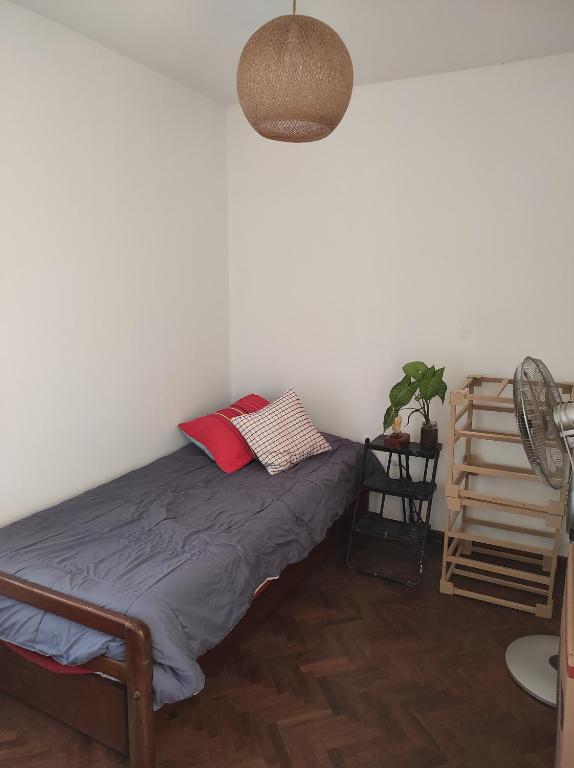 sypialnia z łóżkiem z 2 poduszkami i wentylatorem w obiekcie Dulce Hogar w mieście San Miguel de Tucumán