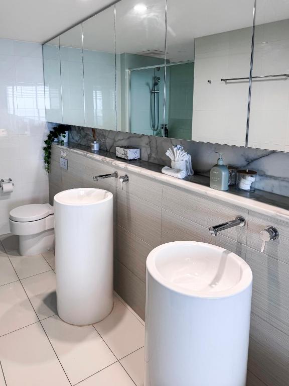 a bathroom with a sink and a toilet and a mirror at Oracle 11th floor Tower 1 - GC Getaways in Gold Coast