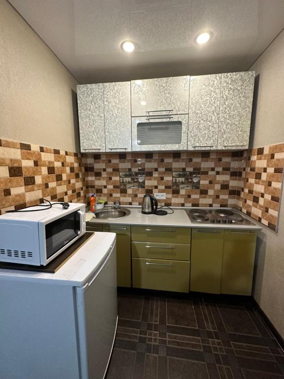 a kitchen with a sink and a microwave at 5 мин международный аэропорт in Prigorodnyy
