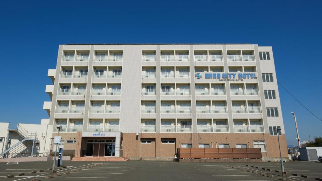 um grande edifício branco com um cartaz em Wind City Hotel em Tahara