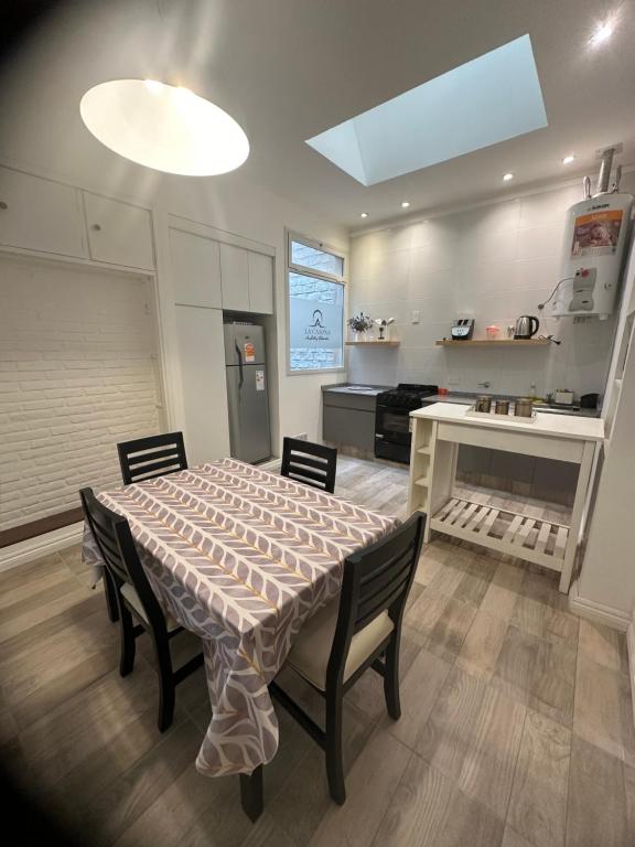 a dining room with a table and chairs and a kitchen at La Casona de Lula y Eduardo in Tandil
