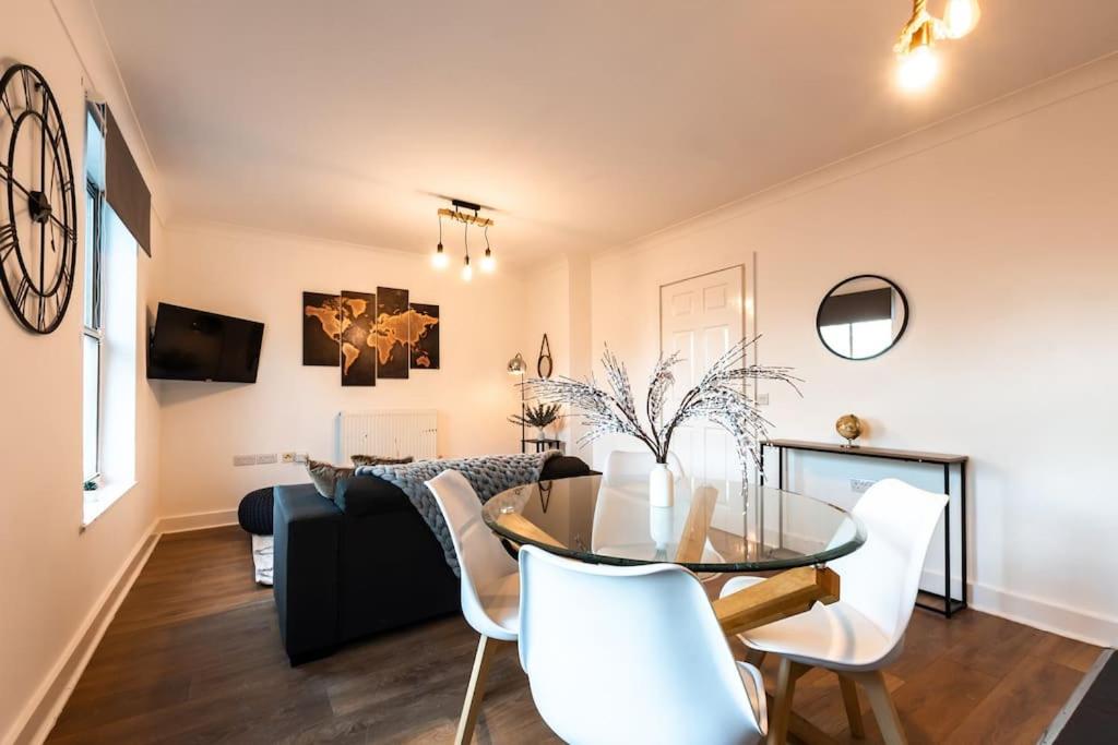 een eetkamer en een woonkamer met een glazen tafel en witte stoelen bij Marigold- 2 Bedroom, Sleeps 5 in Southampton