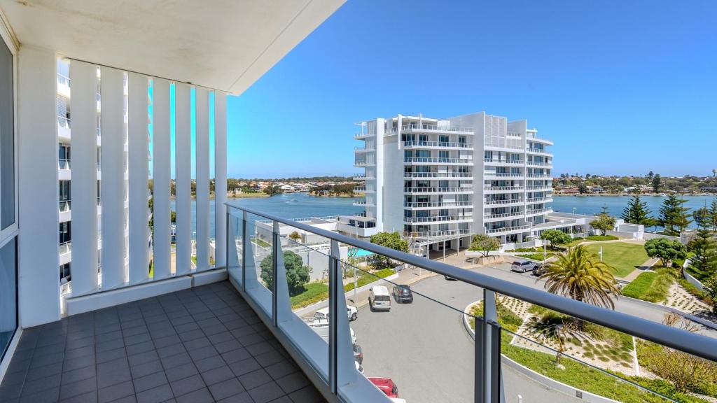 a balcony with a view of the ocean and buildings at Bayview 608 in Mandurah