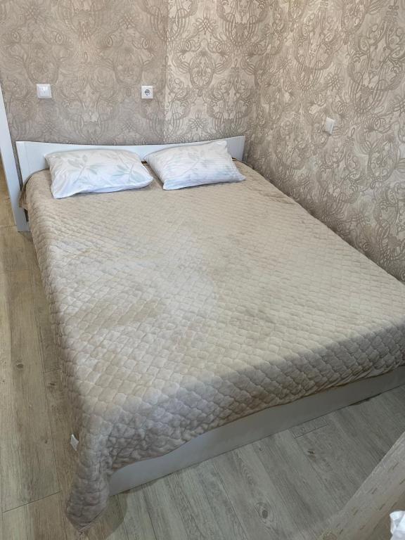 a bed with two pillows on top of it at Аэропорт 5 минут in Prigorodnyy