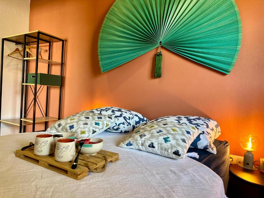 a bed with two pillows and a green umbrella at Bahia Beach- Duplex, plage privée, Netflix in Cayenne