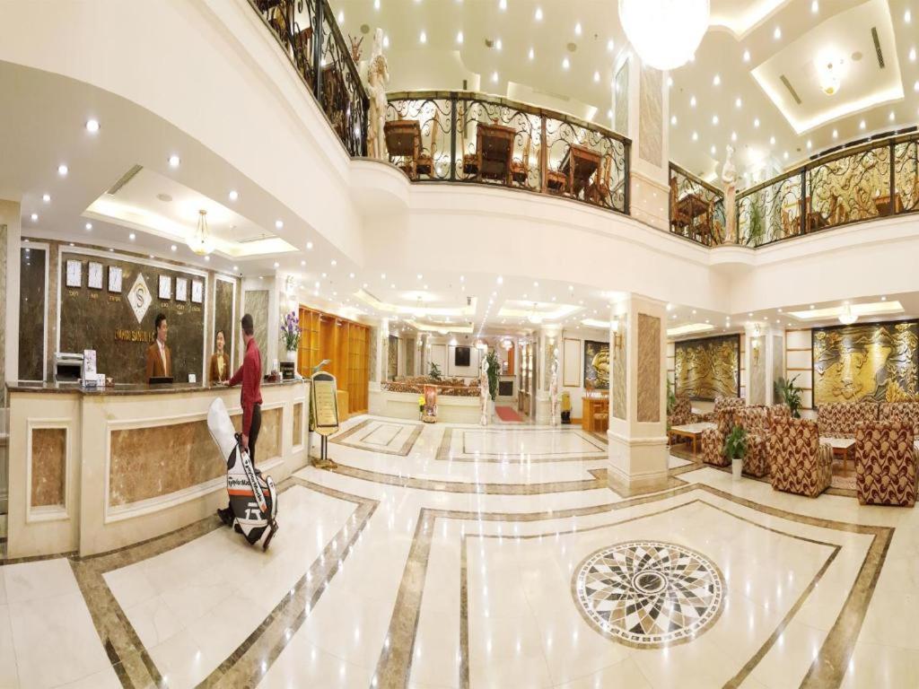 un vestíbulo de un hotel con una mujer de pie en el vestíbulo en A25 Luxury Hotel en Hanói