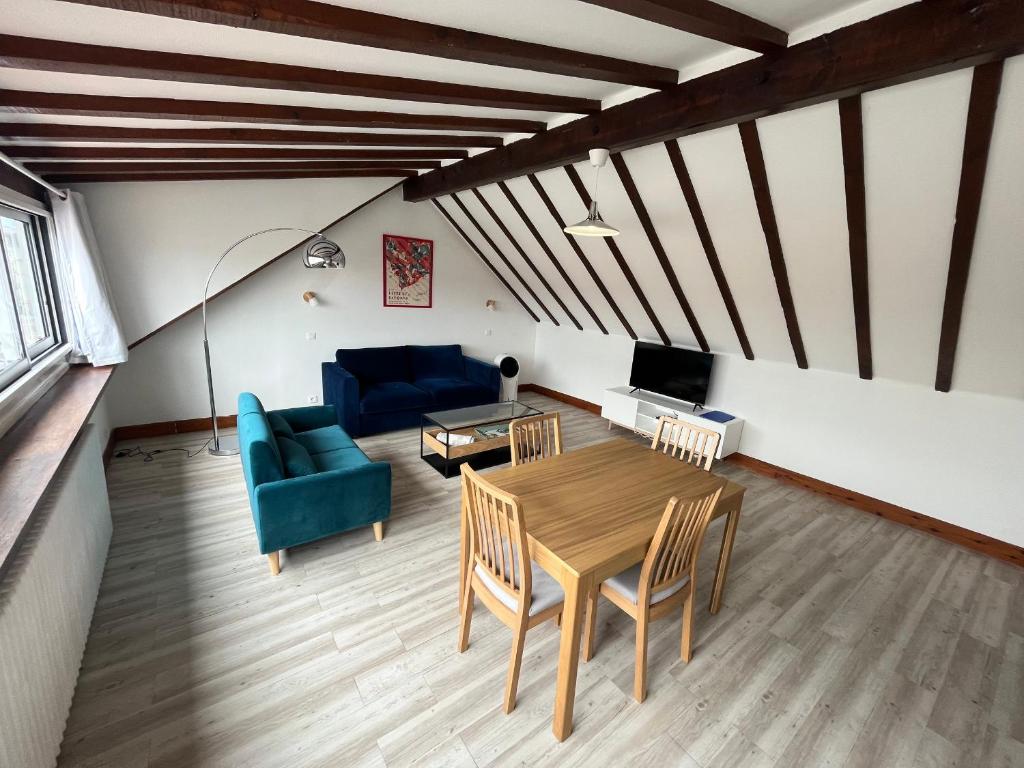 a living room with a table and a blue couch at Grand studio 65m² à Saint-Esprit, Bayonne - WiFi, près gare - FR-1-239-996 in Bayonne