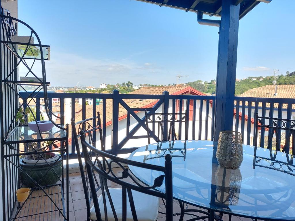 a patio with a table and chairs on a balcony at Maison avec jardin, terrasse et parking proche plage - FR-1-239-772 in Urrugne