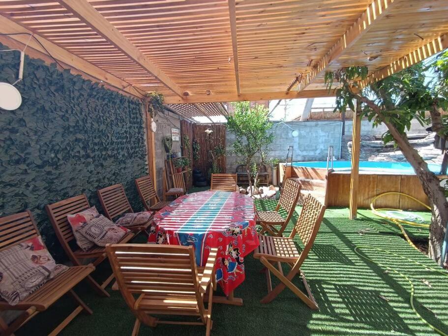 een patio met een tafel en stoelen en een zwembad bij Alojamiento Abigal in Pica