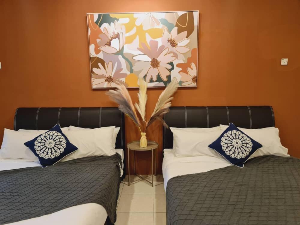 two beds sitting next to each other in a room at Pleasant Stay @ Sunway (16-20 pax ) 5 min to Lost World of Tambun in Tambun