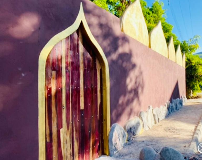 um edifício com uma porta de madeira ao lado em Kalis Inn em Alto Paraíso de Goiás