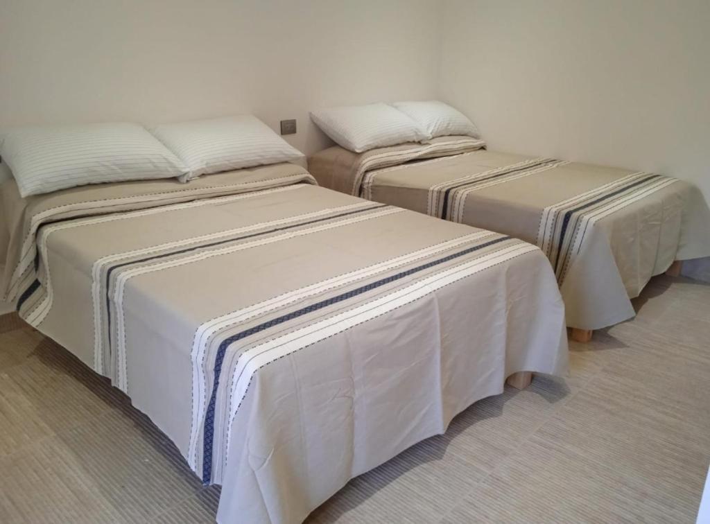 Dos camas en una habitación con cubiertas blancas. en El Peyocuarto, centro de Real14, WIFI., en Real de Catorce