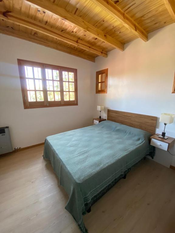 a bedroom with a bed and two windows at Casa Quinta en Gonnet in Manuel B. Gonnet