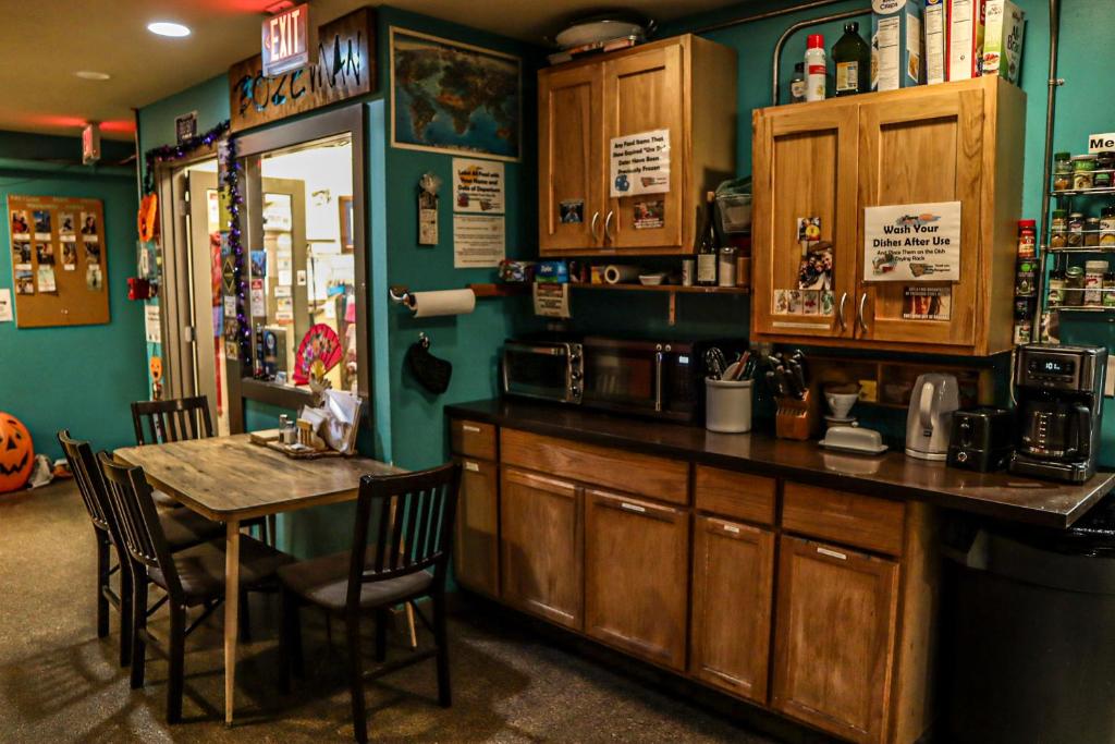 a kitchen with a table and a table and chairs at Treasure State Hostel in Bozeman