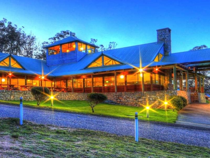a large building with a blue roof at night at Alpine Village Jindabyne in Jindabyne