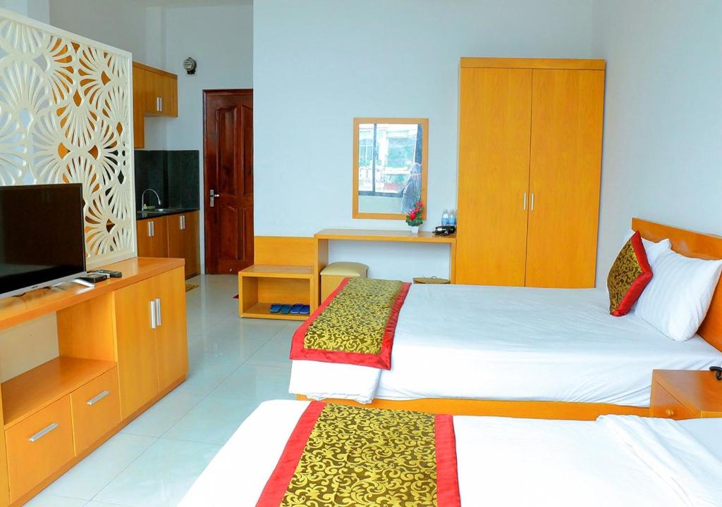 a hotel room with two beds and a television at Khách sạn Phố Ngọc in Nha Trang