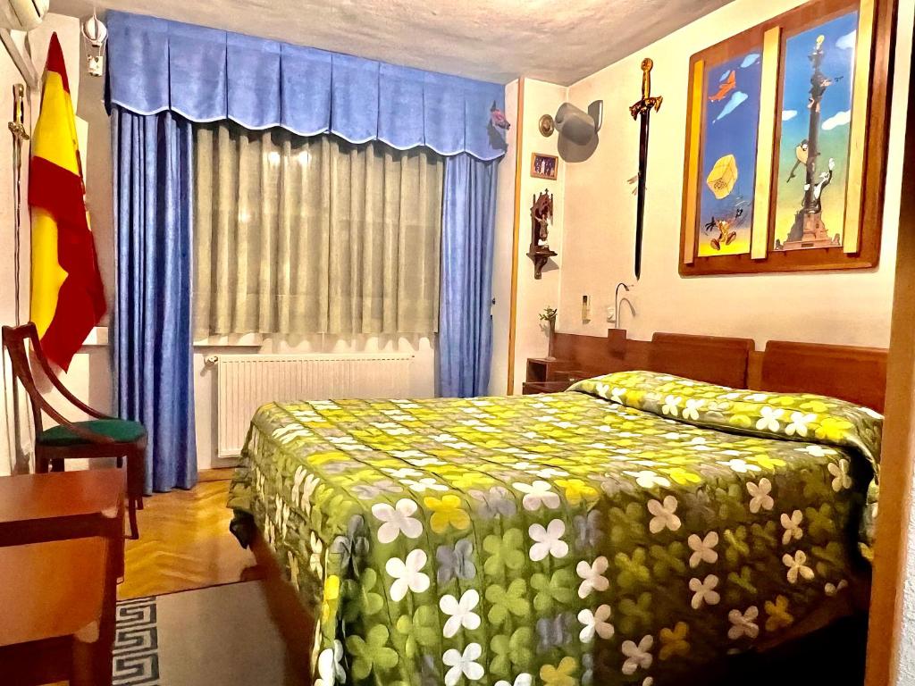 ein Schlafzimmer mit einem Bett mit einer grünen und weißen Decke in der Unterkunft Suite del Manzanares en Madrid in Madrid