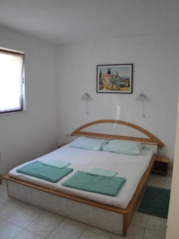 a bedroom with a bed with green towels on it at Apartment Kordić in Sveta Nedelja