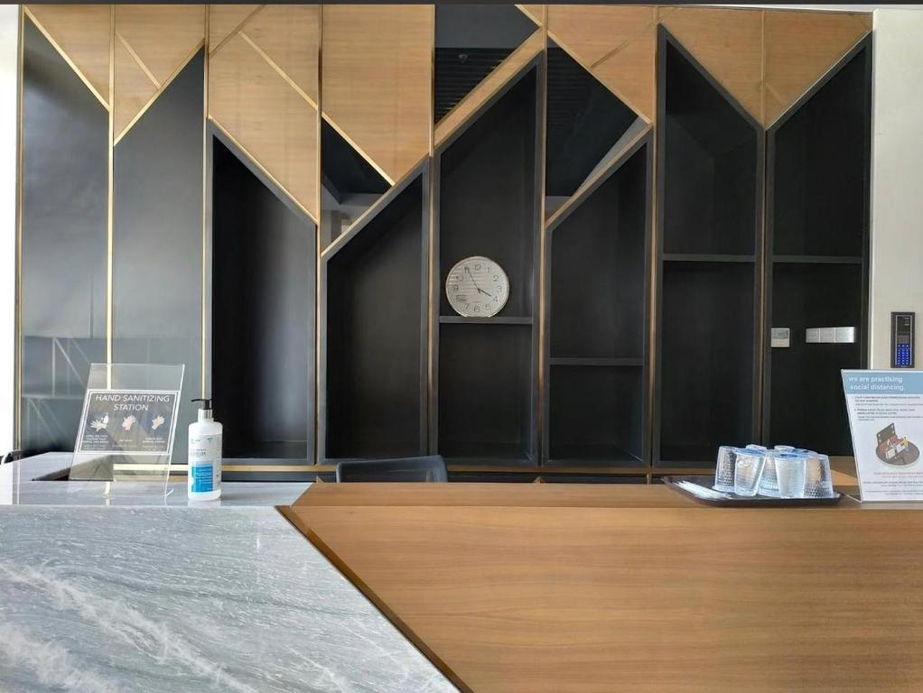 une chambre avec un comptoir avec une horloge sur le mur dans l'établissement GREEN SEDAYU APARTMENT b28, à Jakarta