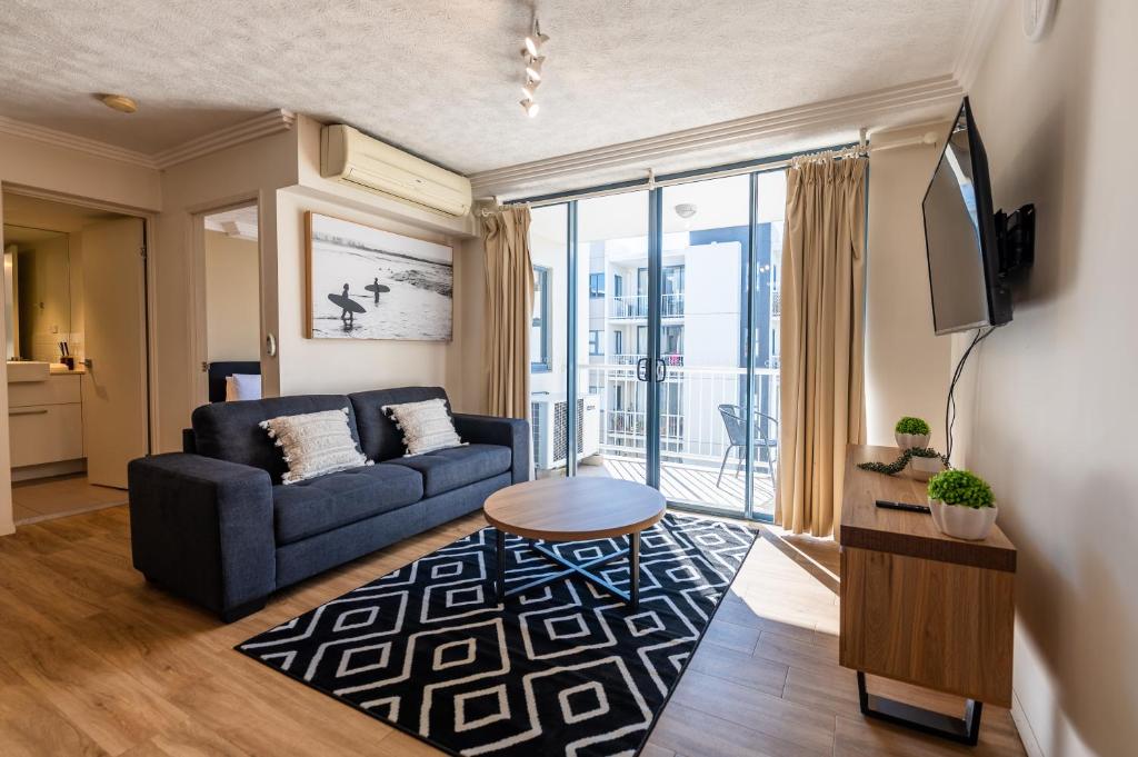 a living room with a couch and a tv at Urban Luxury City Apartment with Pool and Parking in Brisbane