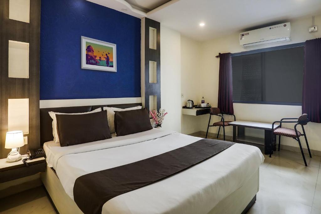 a bedroom with a large bed with a blue wall at Super Capital O 11079 Hotel Prestige in Secunderabad