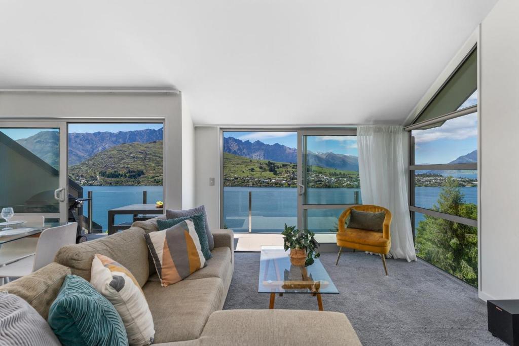 a living room with a couch and large windows at Remarkable Hideaway by Relaxaway Holiday Homes in Queenstown