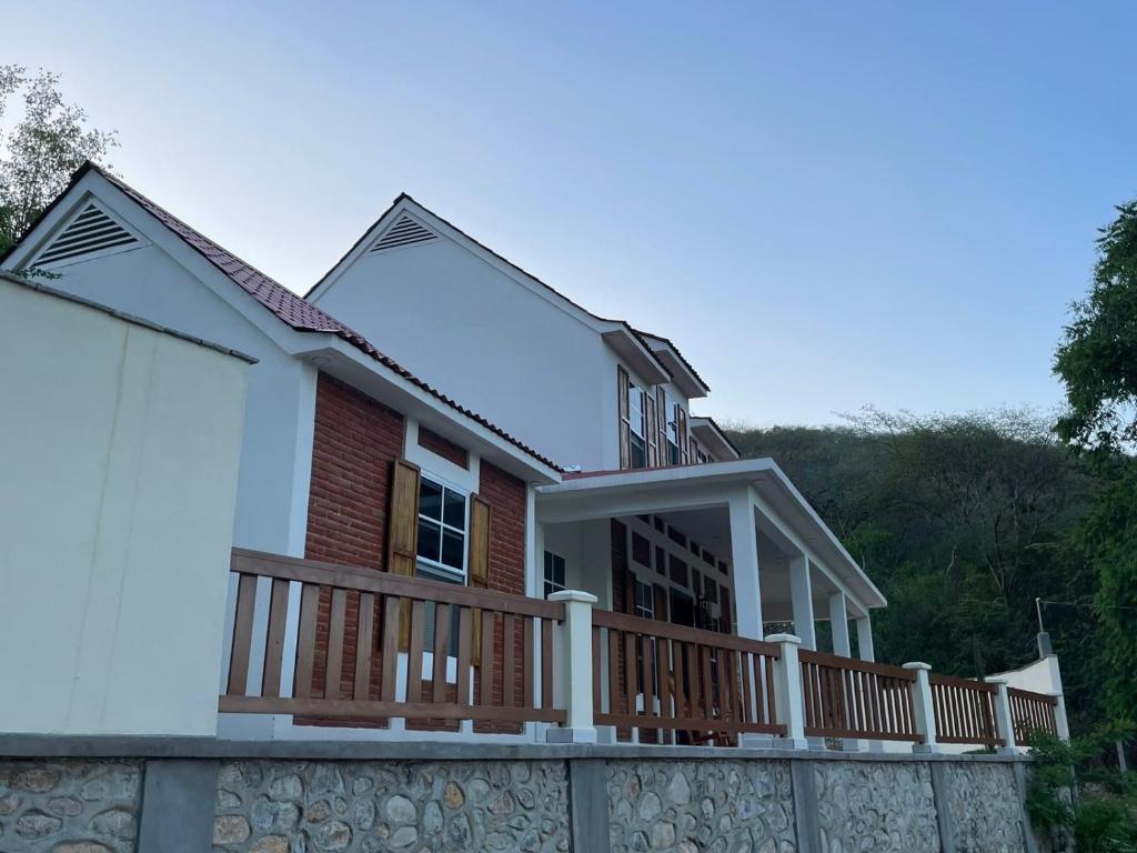 a house with a large deck on a wall at Casa la CEIBA in Tancama