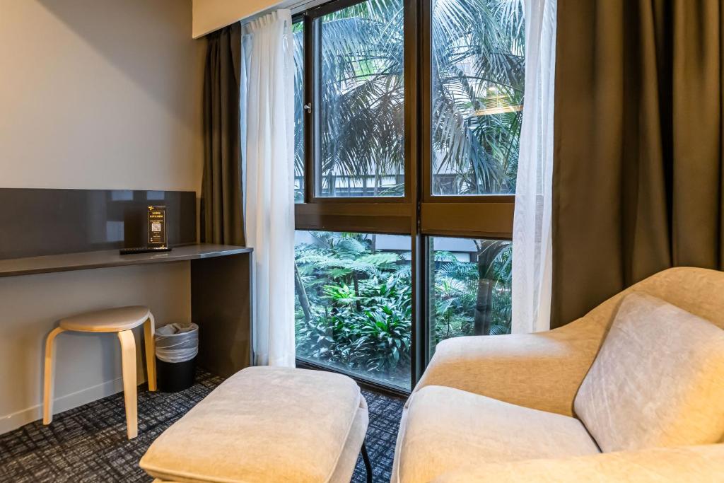 a living room with a couch and a window at Song Hotel Sydney in Sydney