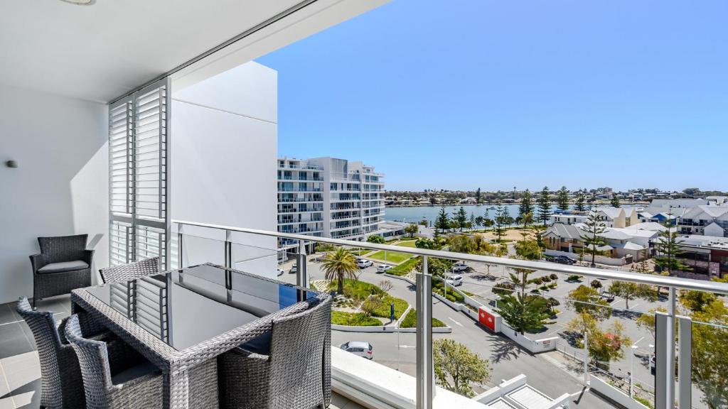 a balcony with two chairs and a view of a city at Bayview 701 in Mandurah