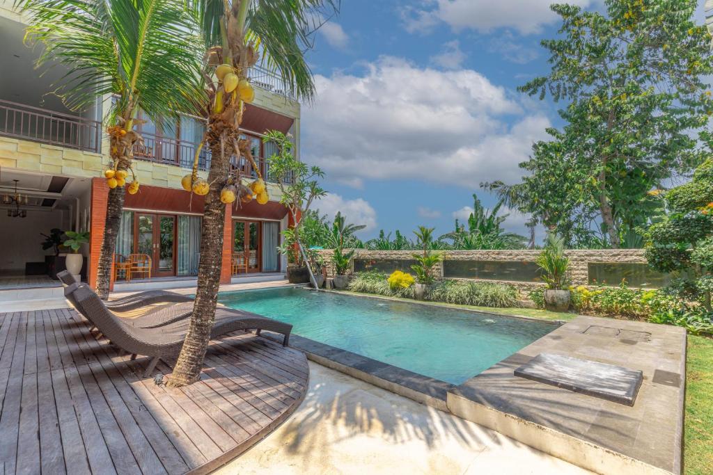 een villa met een zwembad en een palmboom bij Sedana Cottage in Canggu