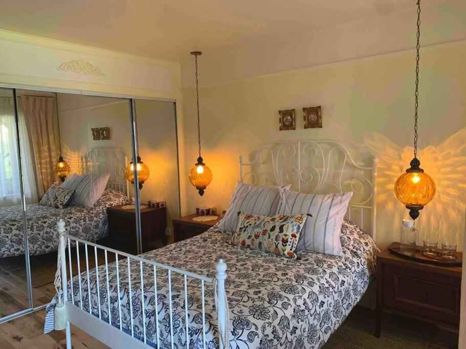 a bedroom with two beds and a large mirror at Havre chez Guylaine in Laval