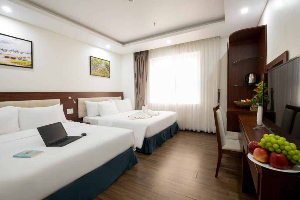 Postel nebo postele na pokoji v ubytování Dao Ngoc Hotel Da Nang