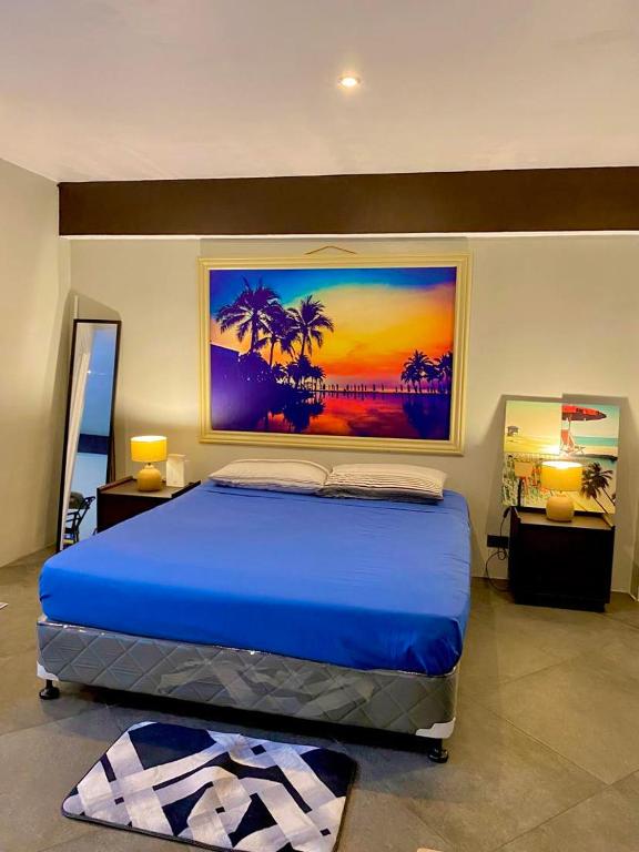 - une chambre dotée d'un lit bleu et d'une peinture murale dans l'établissement The Layover - nearest to airport, à Lapu Lapu City