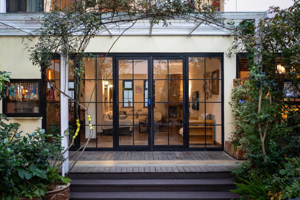 une porte en verre ouverte d'une maison avec une terrasse dans l'établissement Dali Garden, à Dali